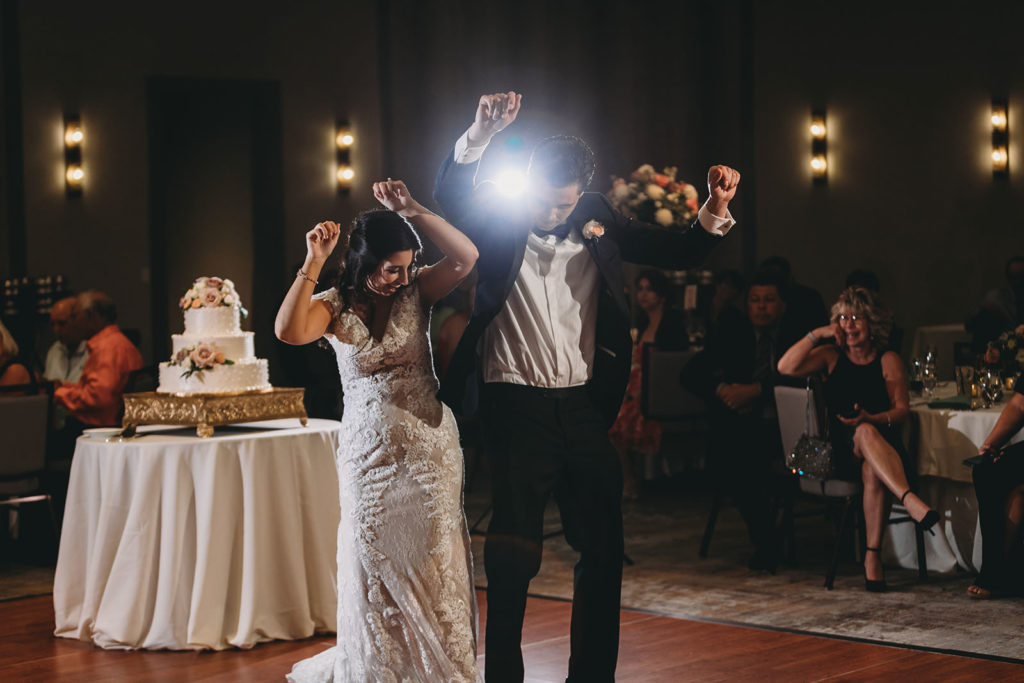 bride and groom bump hips while dancing at embassy suites in south bend during their first dance