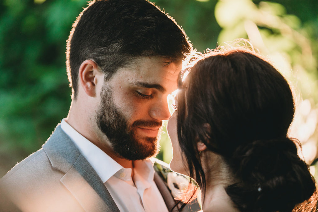 groom touches bride's nose with his nose at sunset during their Carmel backyard wedding
