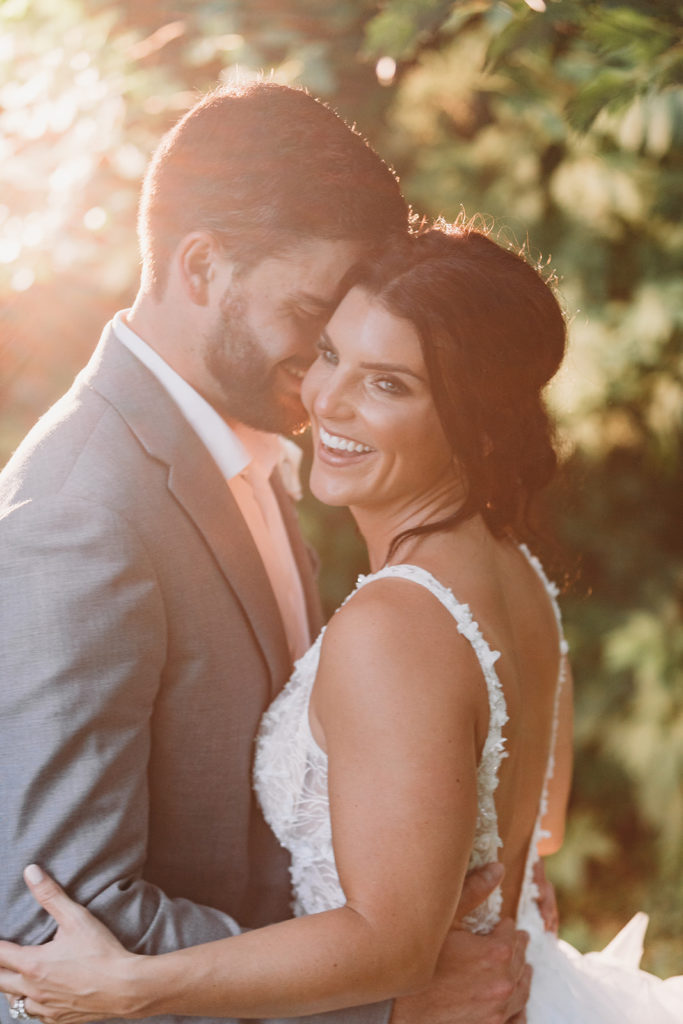 bride and groom hug and laugh at sunset during their Carmel backyard wedding