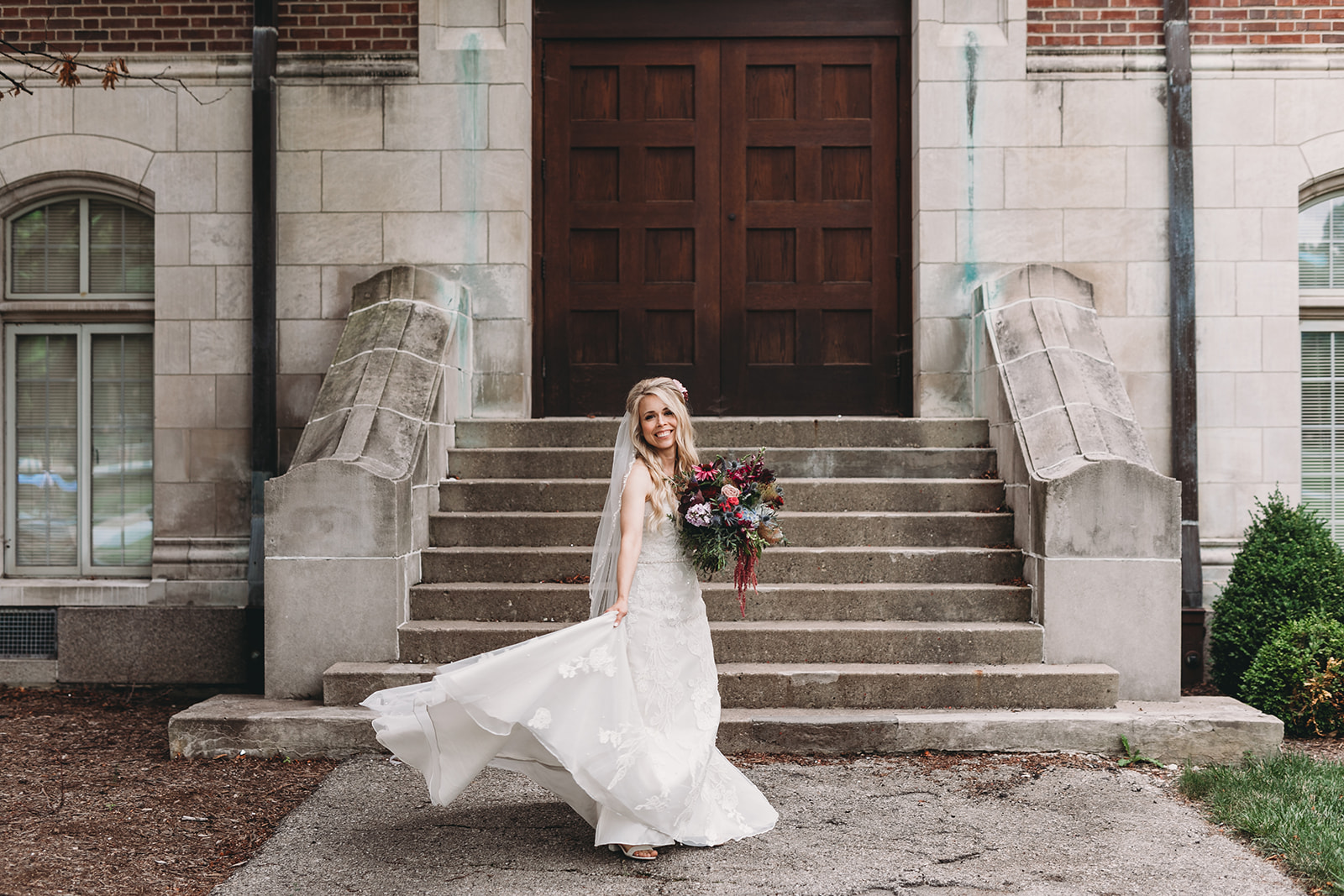 beautiful blonde bride standing in front of steps of building for her unique wedding photos