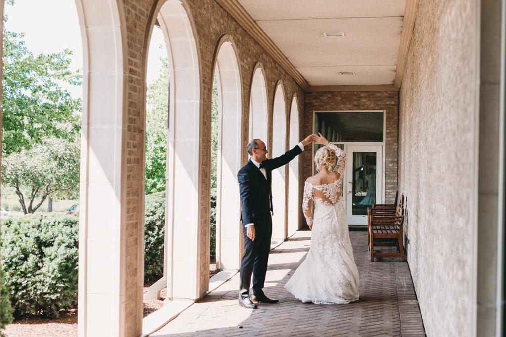 bride and groom dance under overhang after their first look at their sand creek wedding
