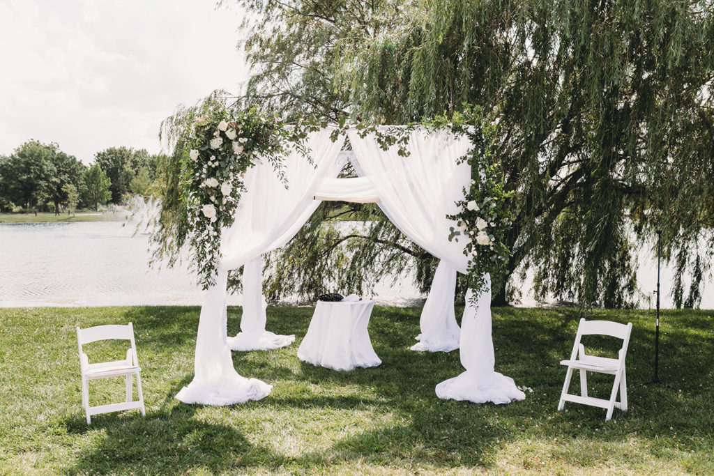 chuppah set up on waterfront by weeping willow tree at a charming coxhall gardens wedding