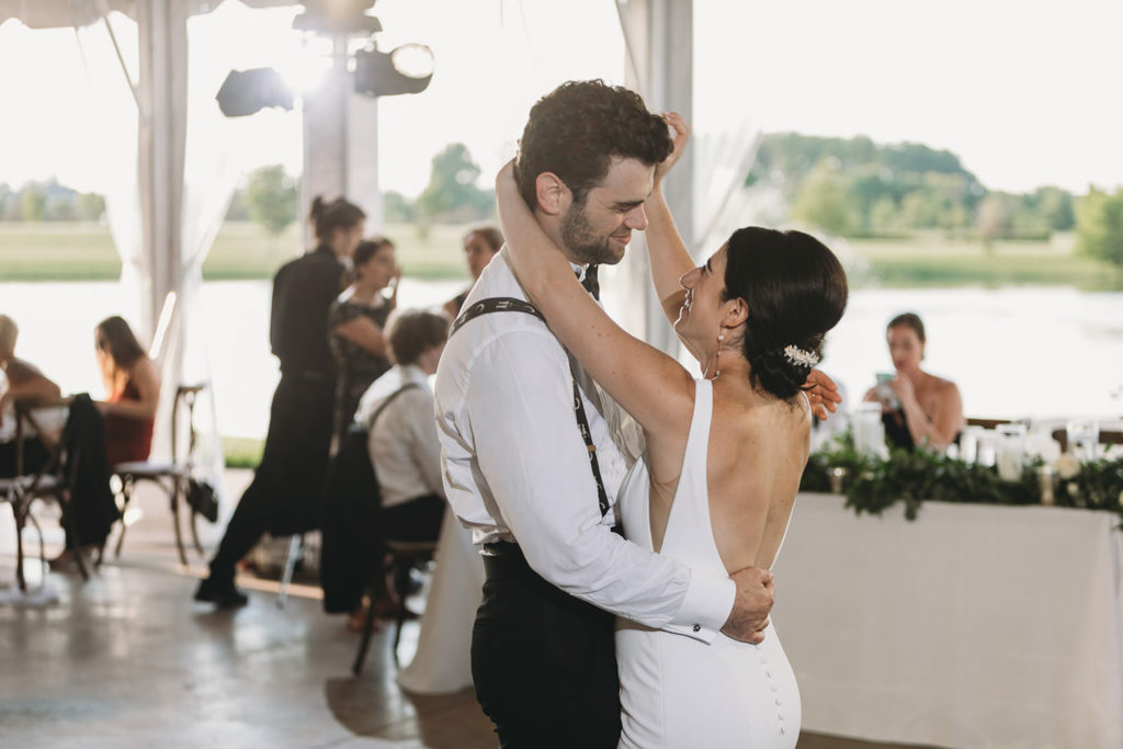 first dance with bride and groom under tent with pond in the background at their charming coxhall gardens wedding