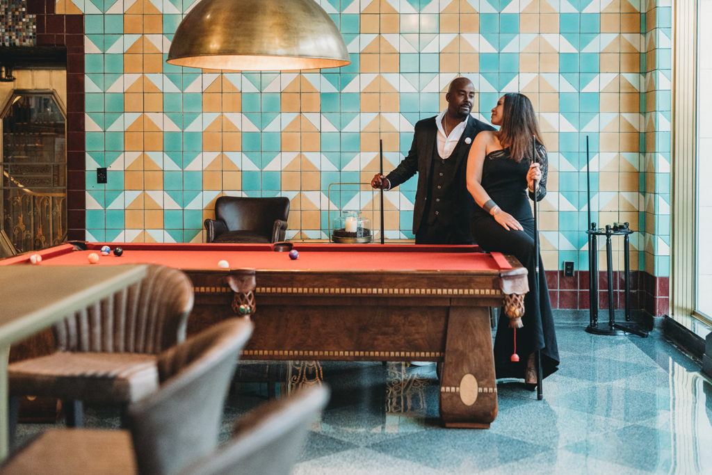 man and woman play pool in hotel lobby in Indianapolis 