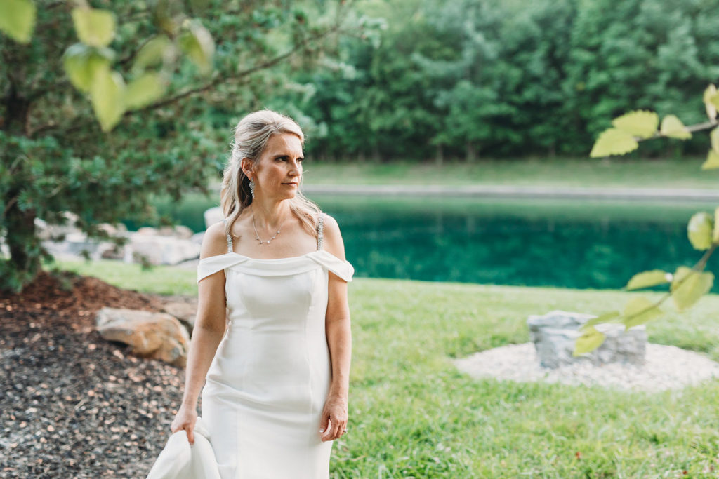 bride walking in front of a pond