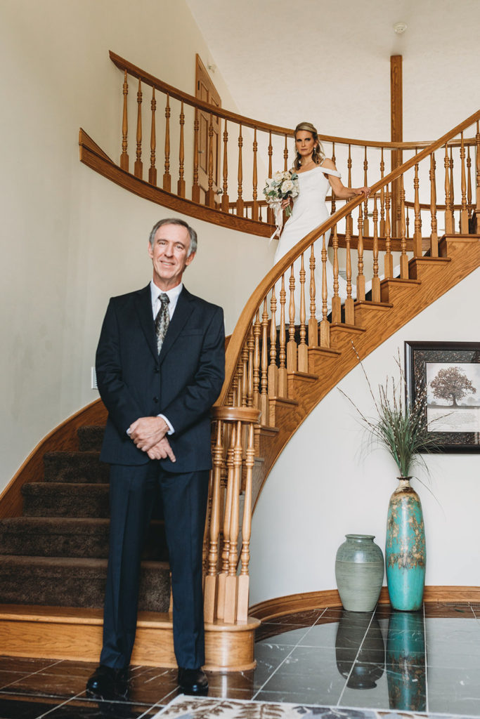 bride walks down stairs to see groom for first look during their five willows wedding