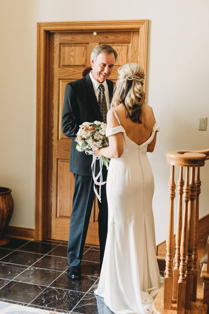groom smiles as he sees bride for first time during their five willows wedding