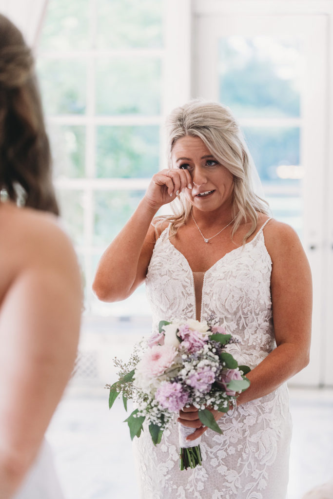 bride cries and wipes tears from her eyes during a marian university wedding