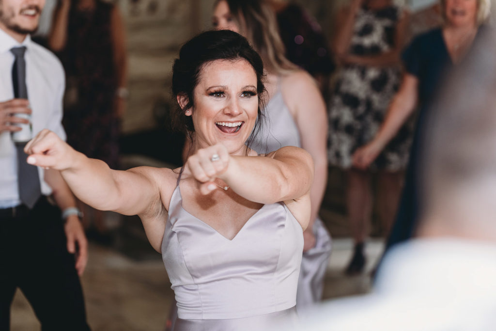 a woman dances during the reception at a marian university wedding
