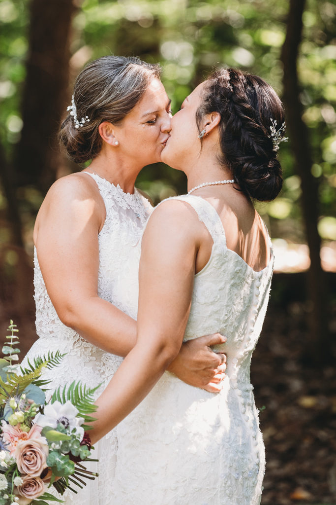 two brides kiss in the woods during their Martinsville wedding