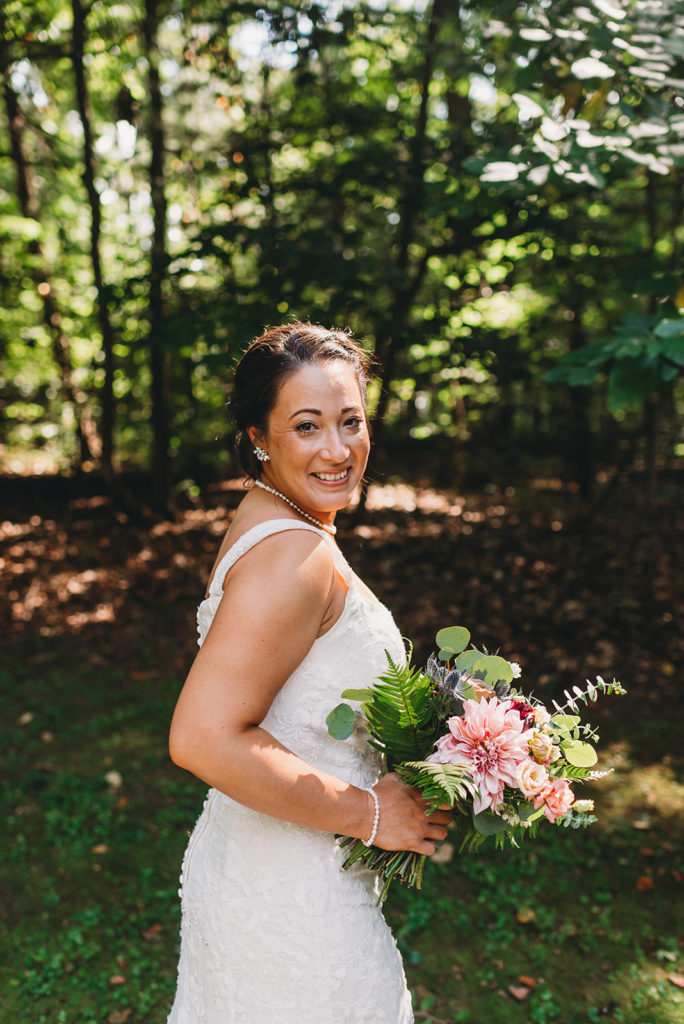 bride with black hair in dress in the woods during a Martinsville wedding