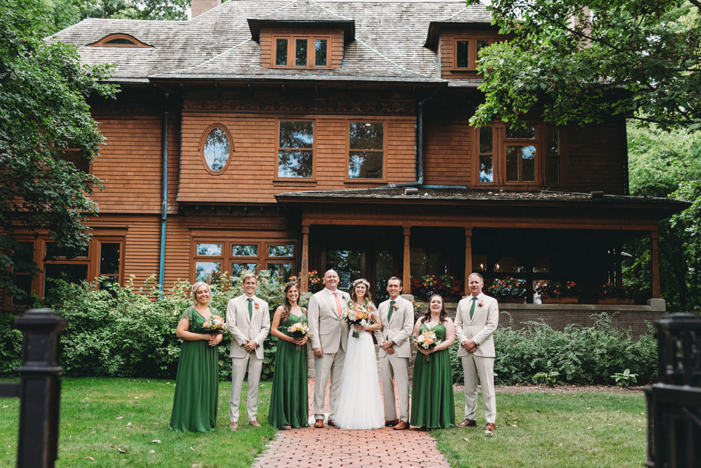 group photos in front of the ball house with the masked man photoshopped out of the window during their Minnetrista wedding