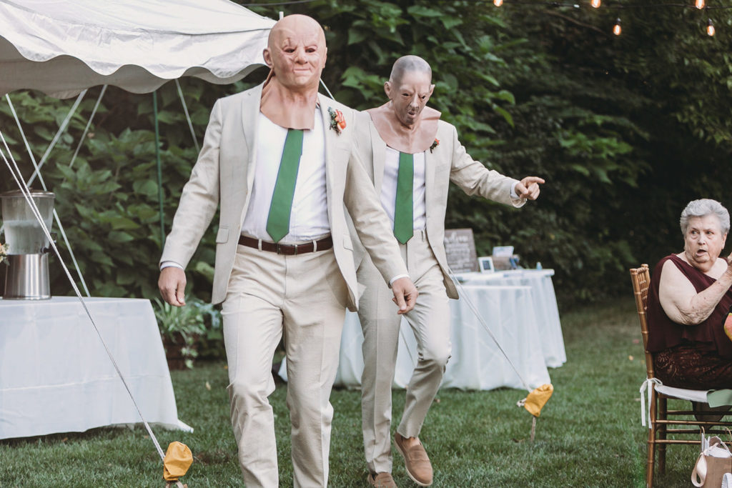 two men in creepy bald masks dancing during their Minnetrista wedding