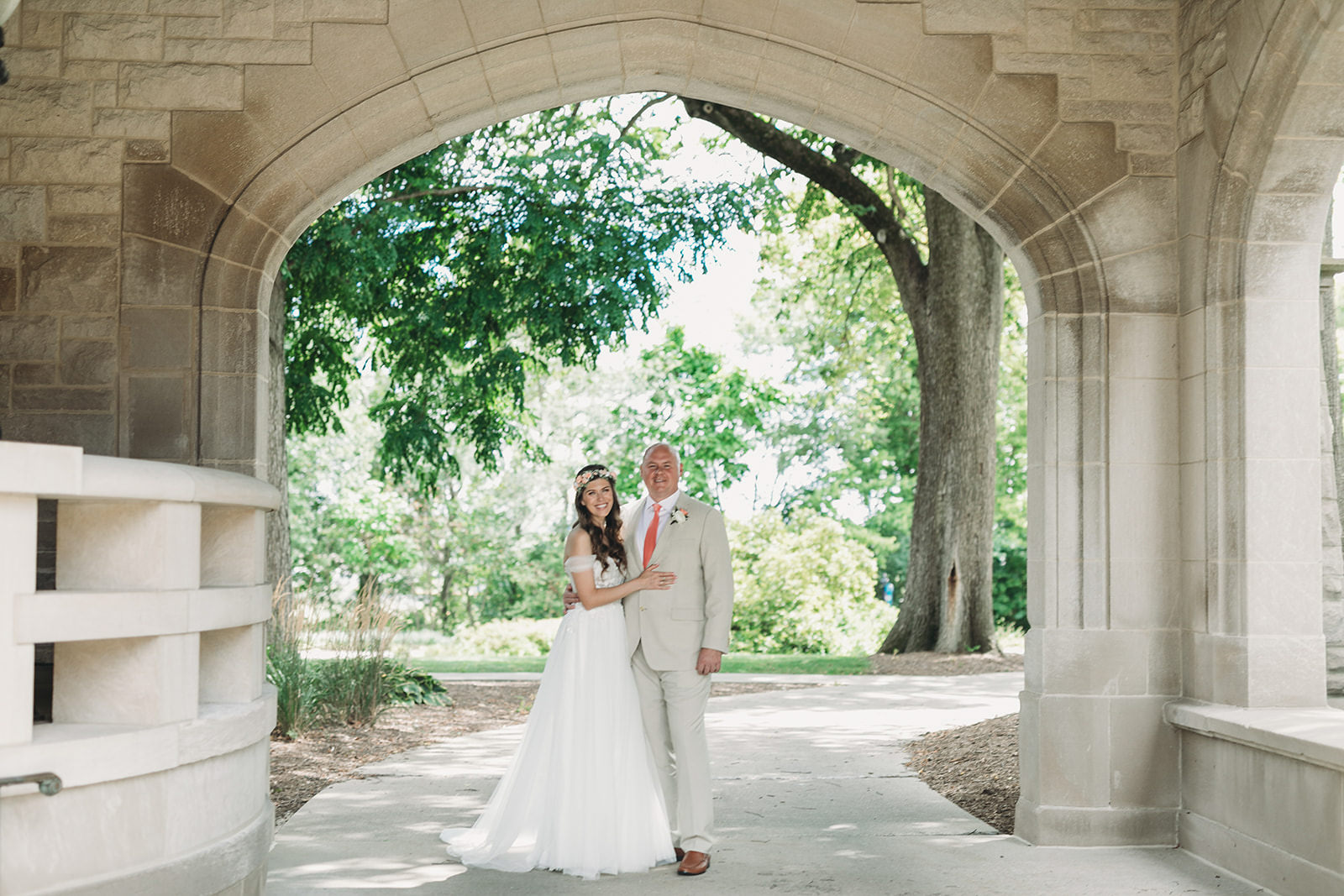 bride and groom under beautiful stone arch during their Minnetrista wedding