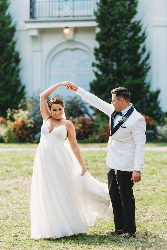 bride and groom dance in front of lilly house in oldfields during a Newfields Lilly Terrace wedding