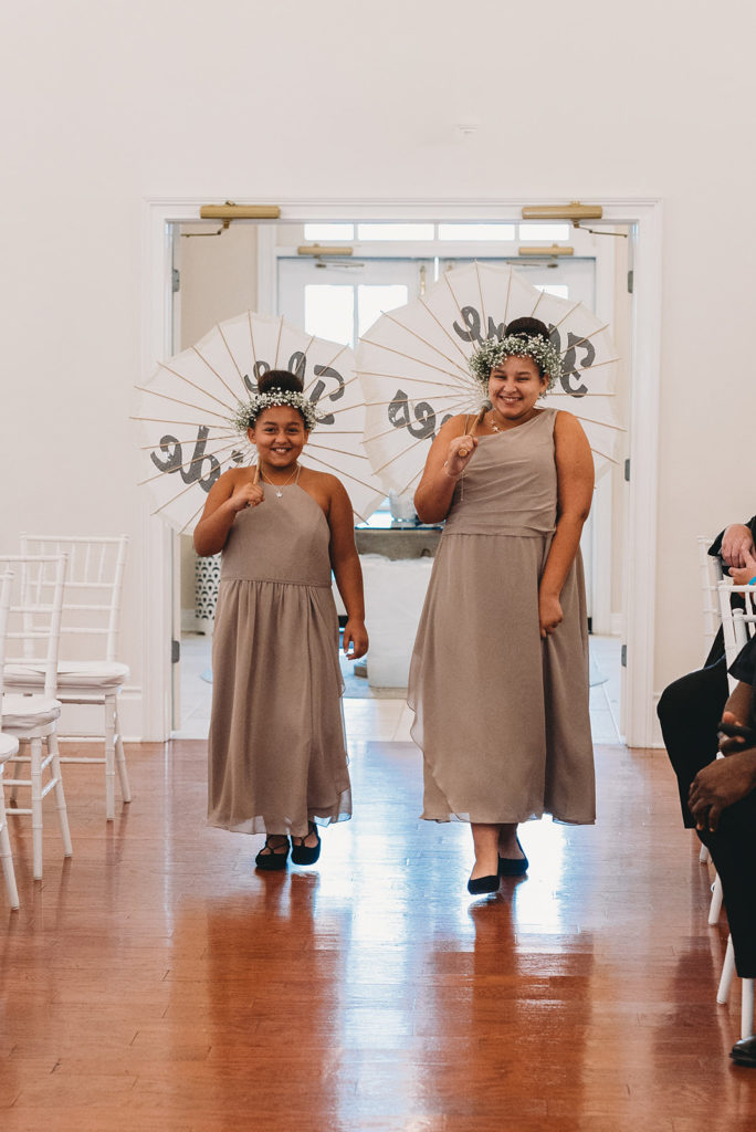 two flower girls with flower crowns carrying umbrellas during their Ritz Charles wedding