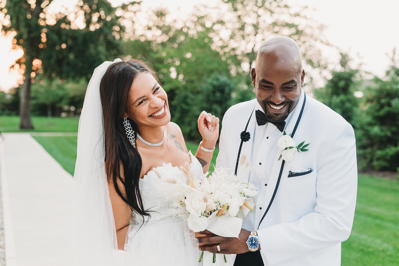 a couple dressed in white laugh at sunset at their Ritz Charles wedding