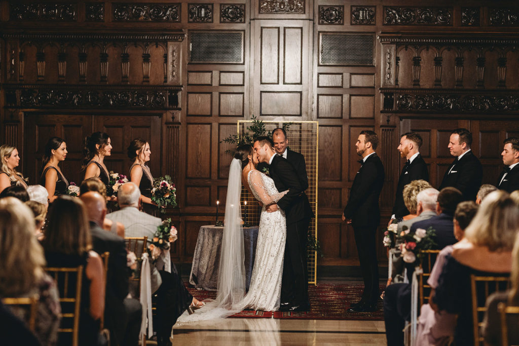 first kiss of bride and groom during a scottish rite cathedral wedding