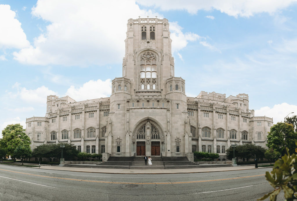wide shot of scottish rite cathedral as bride and groom walk outside during a scottish rite cathedral wedding