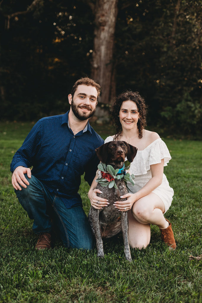 man and woman take a knee with their dog during their Artisan Acres Estate engagement