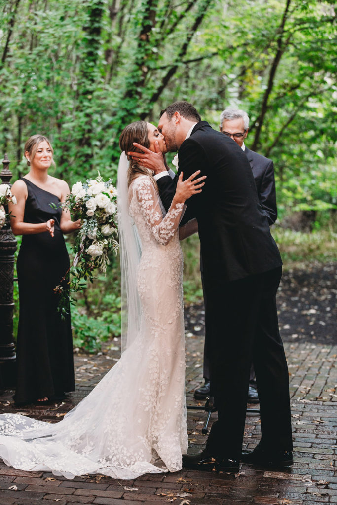 mid shot of bride and groom kissing during their wedding ceremony during their Artisan Acres Estate wedding