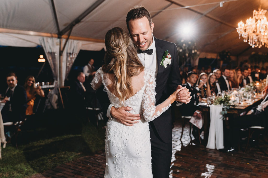 flash pops behind bride and groom as they share their first dance during their Artisan Acres Estate wedding