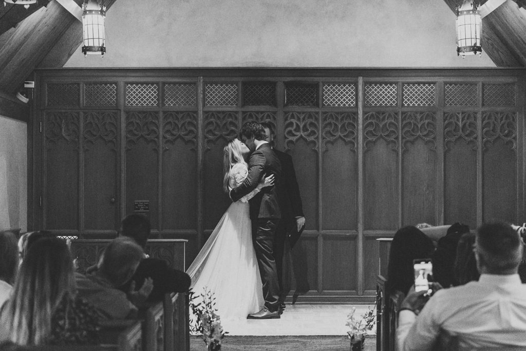 black and white photo of bride and groom's first kiss at beck chapel during their indiana university wedding