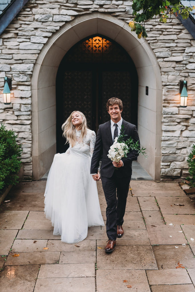 bride and groom walk away from beck chapel during their indiana university wedding