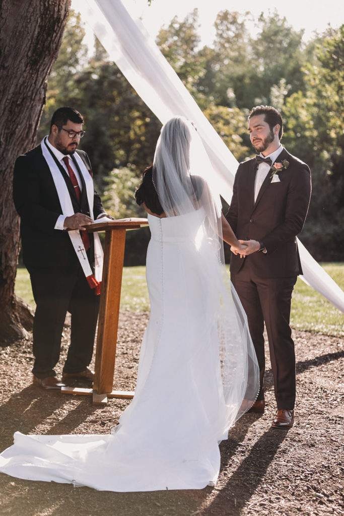 groom looks lovingly at bride during ceremony during their mustard seed wedding