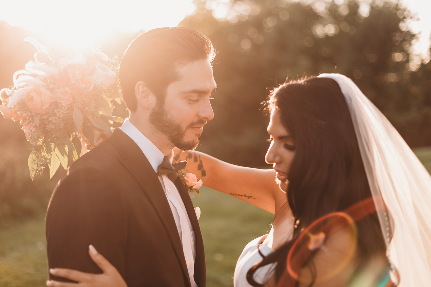 a man and woman in wedding clothes kiss at sunset during their mustard seed wedding