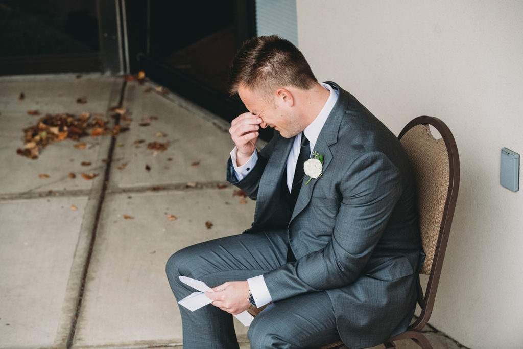 groom cries while reading letter from bride during their charming carmel wedding