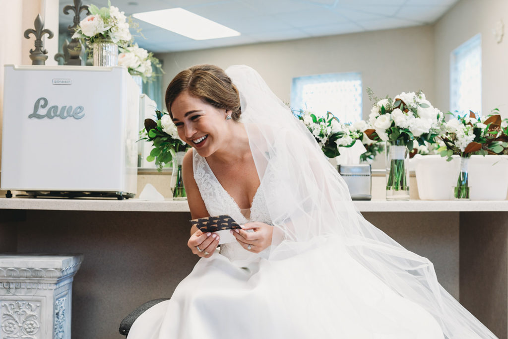 bride laughs while reading letter from groom during their charming carmel wedding