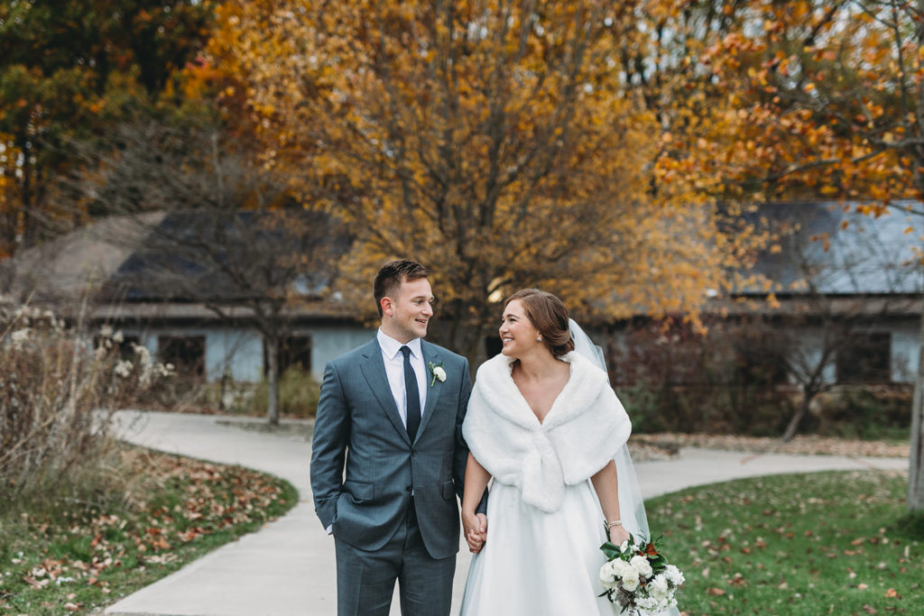 bride and groom with yellow leaves behind them during their charming carmel wedding