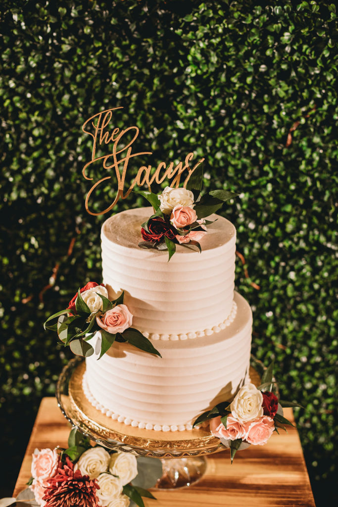 wedding cake with topper that says the stacys during their garment factory events wedding