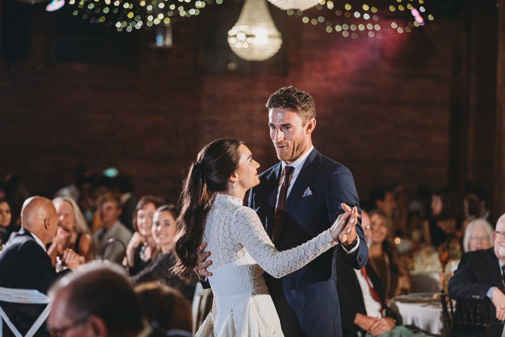 bride and groom dance under a bunch of stringlights during their mavris reception