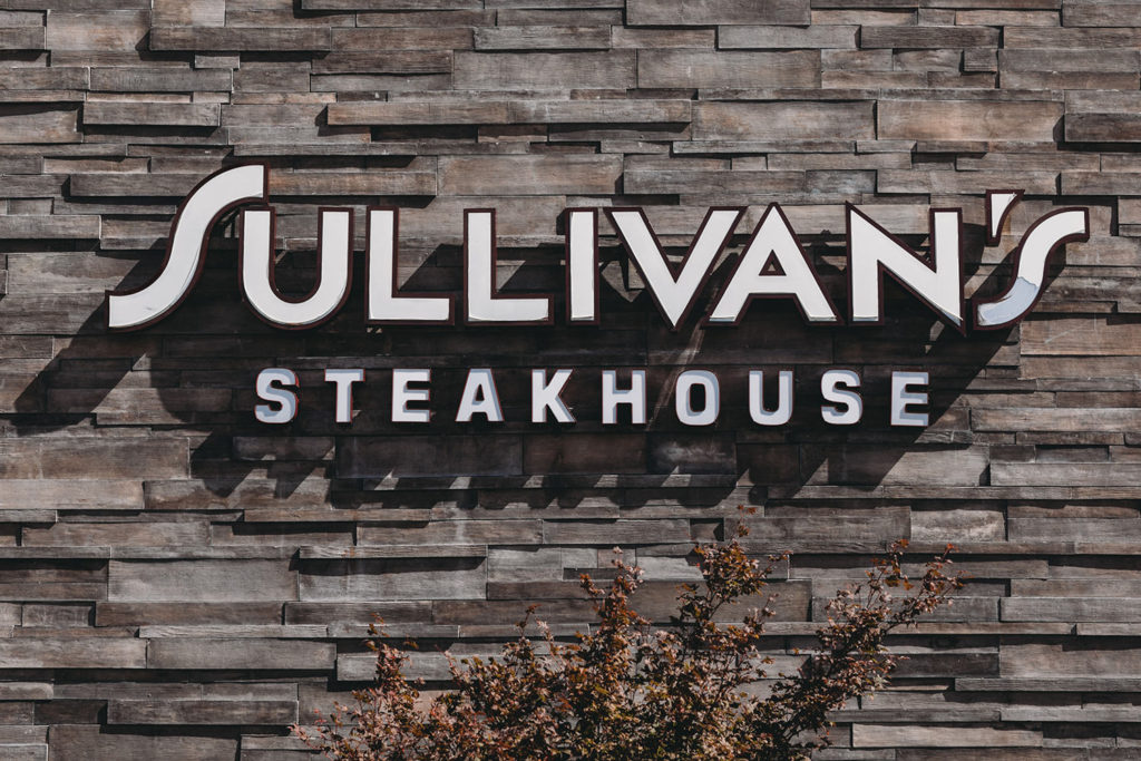 the word's sullivan's steakhouse in white in front of an uneven stone background during a sullivans steakhouse wedding