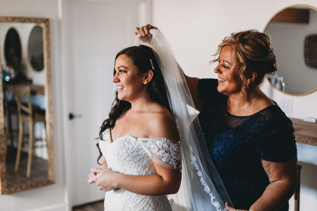 bride's mom puts veil on bride during their white willow farms wedding