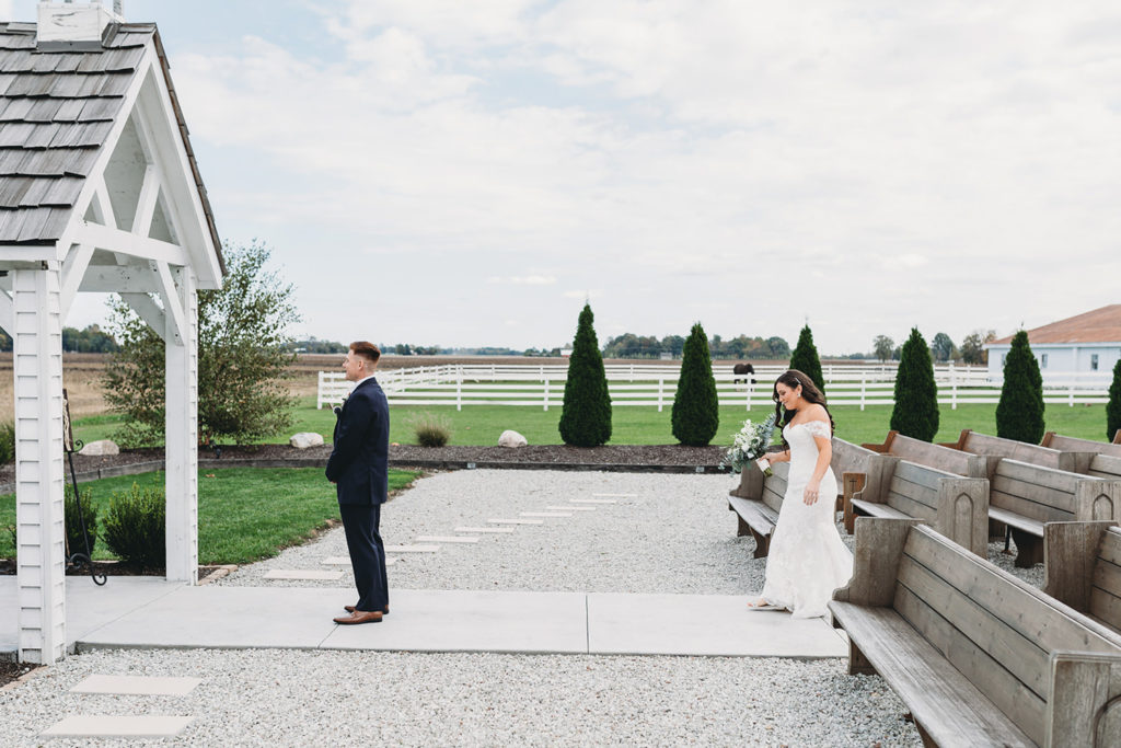 bride approaches groom during first look during their white willow farms wedding