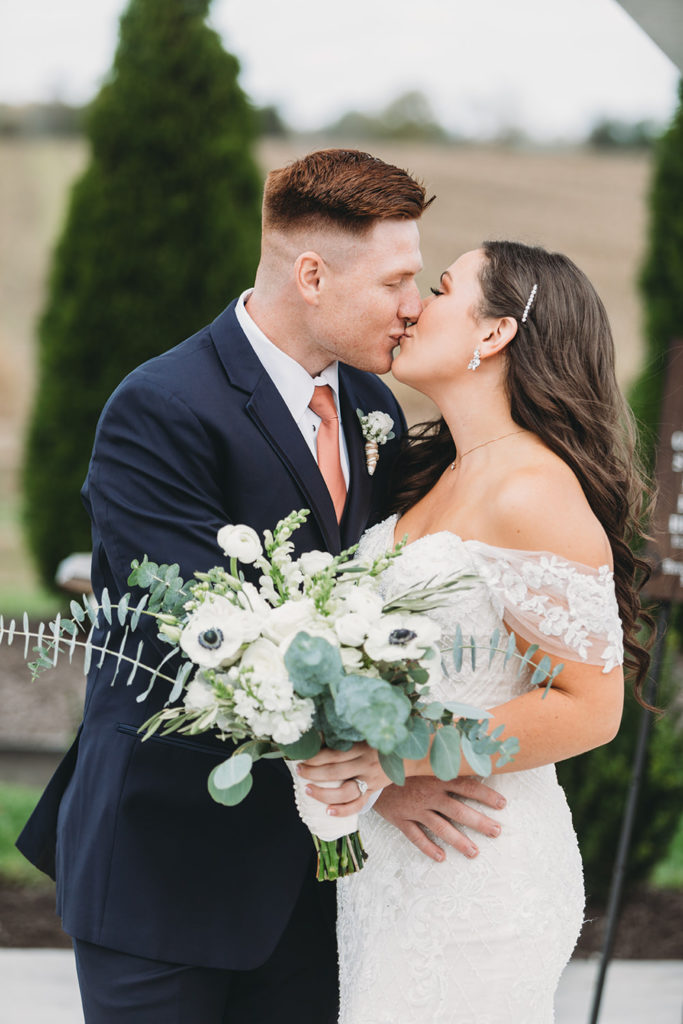 bride and groom kiss during first look during their white willow farms wedding