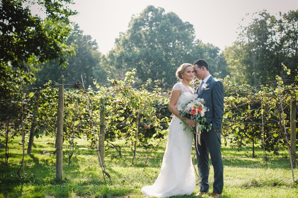 bride and groom hug in front of vineyard at morgan acres one of the Best Indianapolis Barn Venues