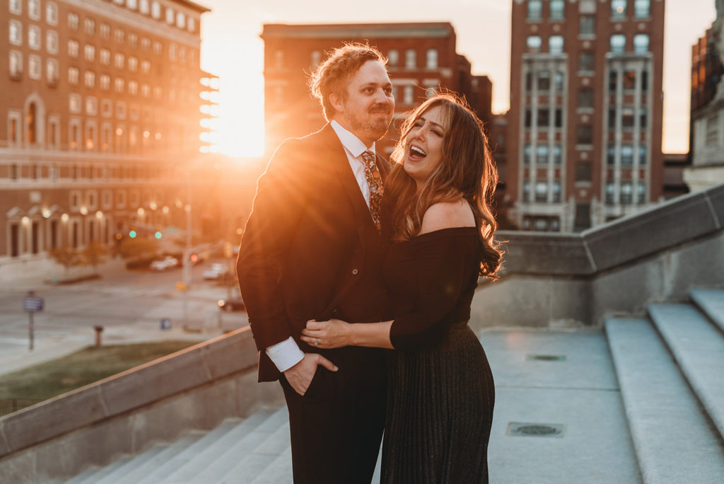 two people make silly faces with old city buildings in the background. multitalented wedding photographers laughing