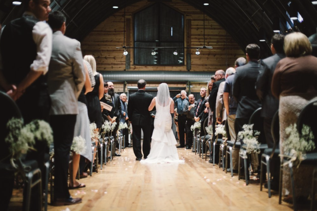 bride walks down the aisle with father in normandy barn, one of the Best Indianapolis Barn Venues