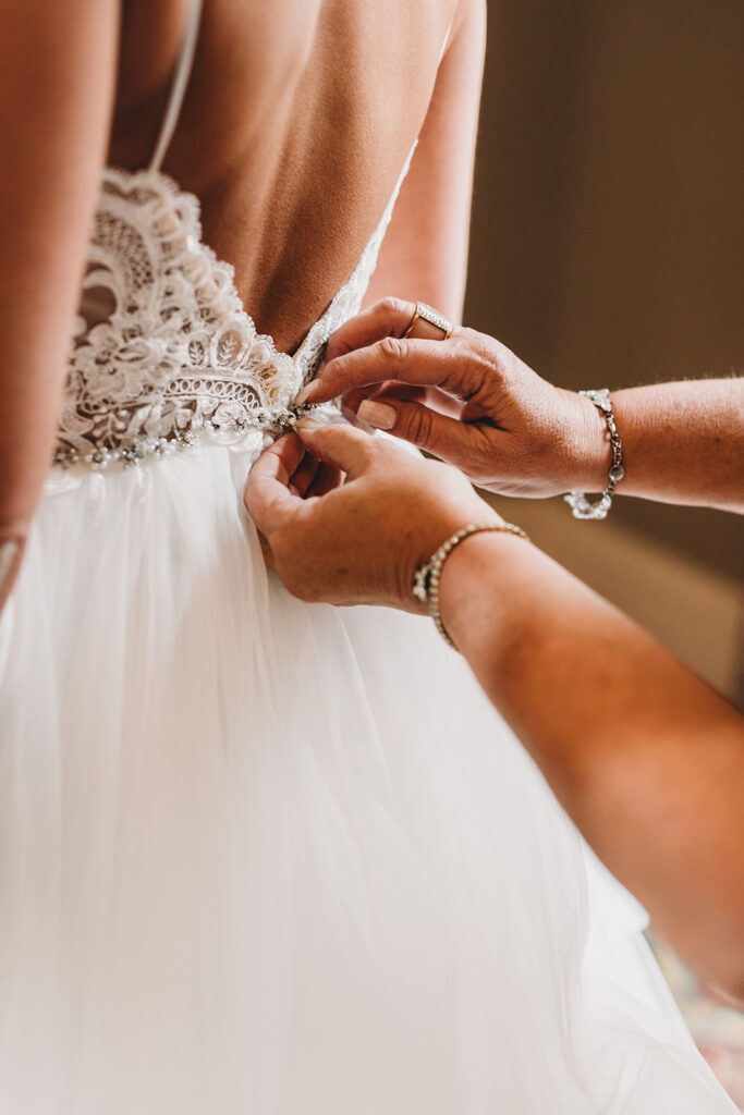 bride's mom buttoning up dress of bride for a Union Station Indy Wedding